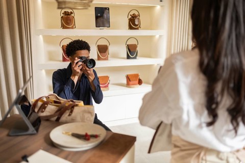 A photographer captures a moment inside a chic bag store, focusing on a beautifully arranged