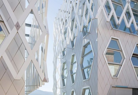 A striking auditorium facade featuring geometric patterns and reflective glass windows, showcasing