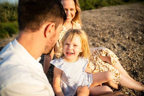 A joyful family on an Italian beach, enjoying a sunny day together. The atmosphere is warm and
