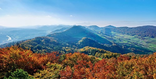 View of an autumnal forest from the Gisliflue, behind the Jura foothills with Wasserfluh and