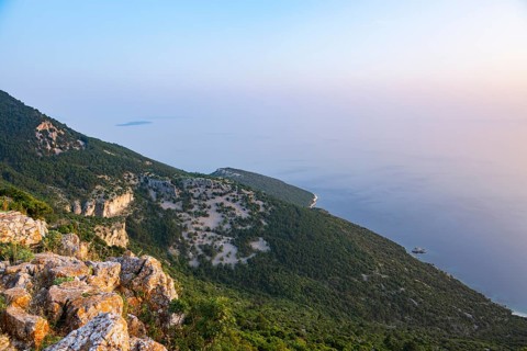 View from Lubenice across the sea with coastal landscape and bays on a sunny day at sunset on the