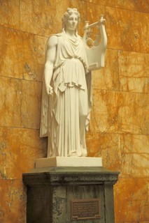 White statue of Apollo with kithara in the foyer, Greek and Roman god of light, lyre, string