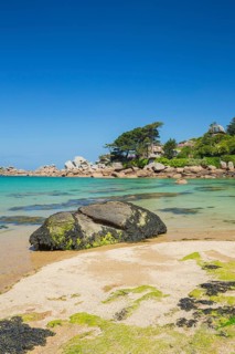 Beach with rocks and sand at the Plage Saint Guirec, with clear blue sky and colors as in the