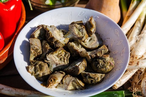 Fresh artichokes and seasonal vegetables, emphasizing Catalan culinary traditions. This
