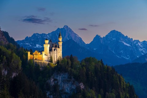 Illuminated castle against a mountain backdrop at night, Neuschwanstein, Schwangau near Füssen,