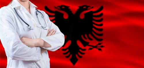 Doctor with crossed arms on Albania flag. Albania health and care concept. Female doctor on Albania