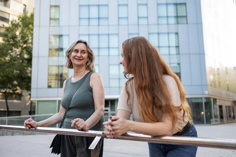 A joyful moment as a mother and daughter enjoy their time outdoors in the city, sharing smiles and