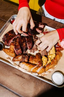 A mouthwatering barbecue platter featuring an assortment of meats, including ribs, sausage, and