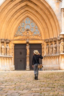 Tourist walking away from the cathedral of tarragona in catalonia, spain, admiring the medieval