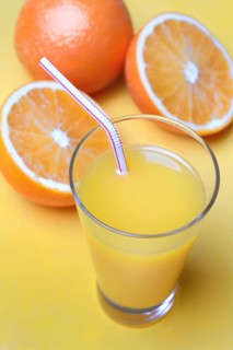 Orange juice in glass and oranges