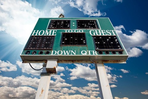 HIgh School Scoreboard Over Blue Sky with Clouds and Sun Rays
