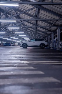 An illuminated car park with a parked electric car on one parking level, Kaufland Calw multi-storey