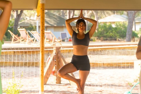 Yoga instructor practicing the tree pose, or vrksasana, during a session in a glamping resort,