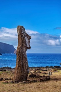 Single moai standing in front of the sea under a blue sky, the moai statues on Easter Island in the