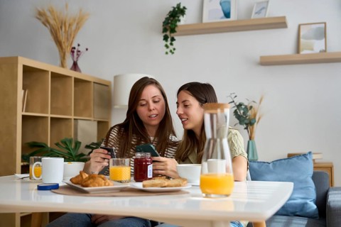A lesbian couple enjoys a cozy breakfast at home, sharing a moment of connection and joy The image