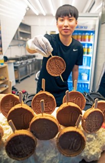 Korean man, 26, showing a mozzarella pancake, Gwangjang market, traditional street market in