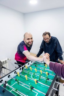 Residents enjoy a lively foosball game in a mental health facility, fostering camaraderie,