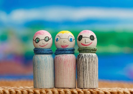 Three small funny wooden cones in front of a painted background, North Rhine-Westphalia, Germany