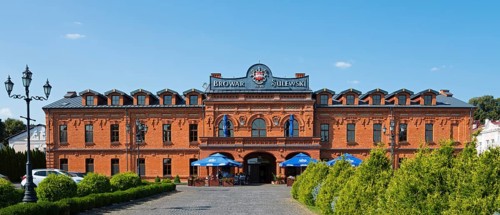 Historic brick building with brewery and restaurant in sunny weather, Sulewski Brewery, Hrubieszów,