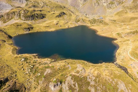 Aerial view of a tranquil mountain lake at Ayous refuge in the French Pyrenees The emerald waters