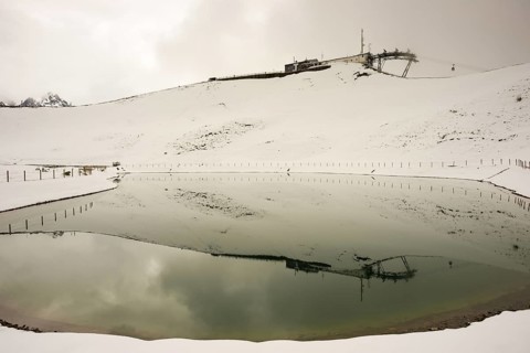 After snowfall in May: Riezler Alpsee, an artificial lake, snow pond, feeds the snow cannons that