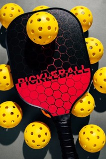 Top view of a vibrant pickleball setup featuring a black and red paddle surrounded by scattered