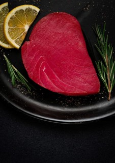 Fresh red tuna fillet, for steak, raw, top view, on a black plate, no people