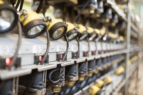 Mining head lamps on the shelves in the mine's lamp room