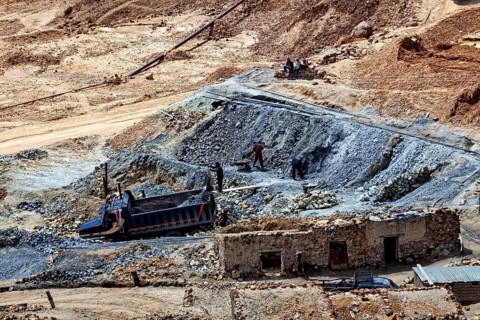 Workers in an open mine accompanied by a truck, rugged terrain, The Potosi silver mines on Cerro