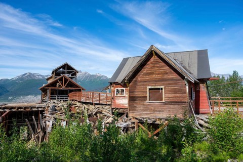 Red Kennicott buildings in front of mountainous landscape, Kennicott Concentration Mill to extract