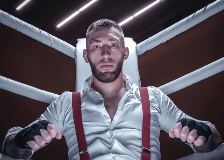 Images of a bearded man in a white shirt and red suspenders in the ring. The concept of fist