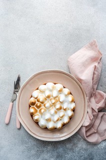 A beautifully presented homemade lemon cake on a pastel pink plate with a coordinating fork and