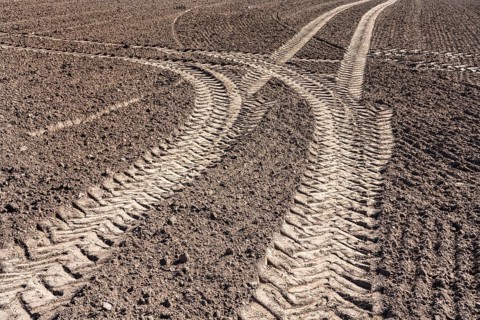 Tractor tracks, agricultural trails at a cultivated field in springtime, farmland near Wesertal,