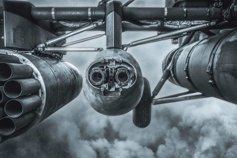 Image of the armament of a combat military helicopter. A missile launcher and a heavy machine gun.