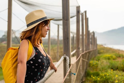 Summer vacation lifestyle. Young adventurous Caucasian girl in a hat enjoying the summer looking at