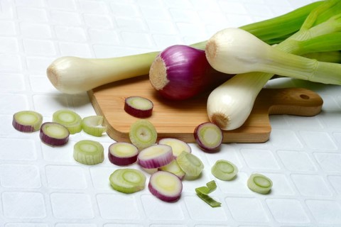 White and purple spring onions and onion slices in their skins, spring onion