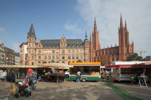 Weekly market on the Dernsches Gelände with customers shopping, pedestrians, market stalls,