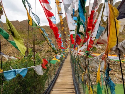 Suspension bridge with prayer flags, highlands of Tibet, China
