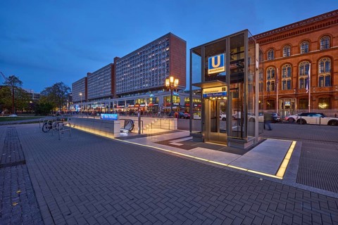 Underground station Rotes Rathaus with lift and residential and commercial buildings at dusk,