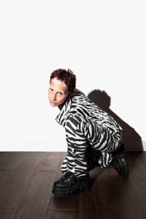 A striking image of a fashion model wearing a bold zebra print ensemble and black platform shoes,