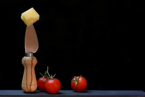 A piece of Swiss Emmental cheese on a cheese knife