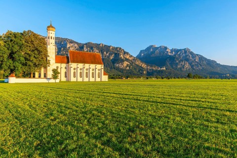 Baroque church St. Coloman, behind it Neuschwanstein Castle and the mountain Saeuling, 2047m,