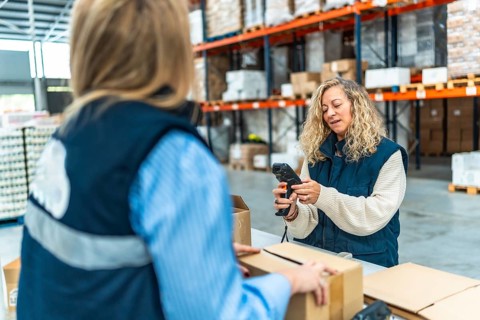 Distribution warehouse female caucasian workers preparing parcels to deliver