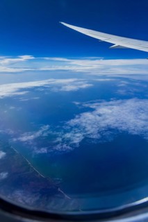 View from the aircraft window during a flight over India with the airline Etihad. Blue sky and