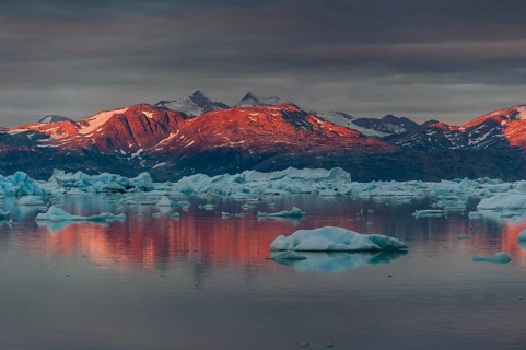 Midnight sun on mountain range, Johan Petersen Fjord, East Greenland, Greenland