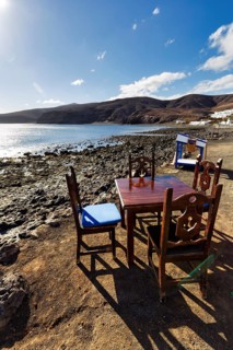 Wooden table and four chairs, fish restaurant on the beach, coastline, Playa Quemada, Yaiza,