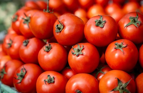 Vendor diaplays tomatoes to sell at a market, on the day of the presentation of Union Budget, in