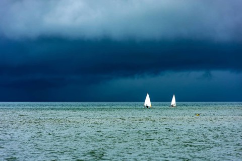 Sailboats sailing the waters of the sea of ??Ilhabela island before the storm, Ilhabela, Sao Paulo,