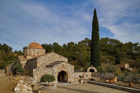 Stone church with cypress and wooded surroundings under a blue sky, monastery, Moni Thari, near