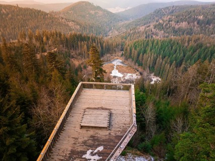 View from platform over wooded hilly landscape with snow, Ellbachseeblick viewing platform,